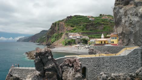 Aerial-past-concrete-pathway-on-rocks-revealing-secluded-beach-in-Madeira