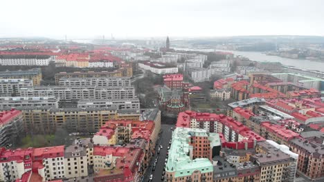 Stunning-zoom-out-aerial-view-of-downtown-Oscar-Fredrik-Church-surrounded-by-skyline-and-buildings-on-a-cloudy-winter-day-in-Gothenburg-City,-Sweden