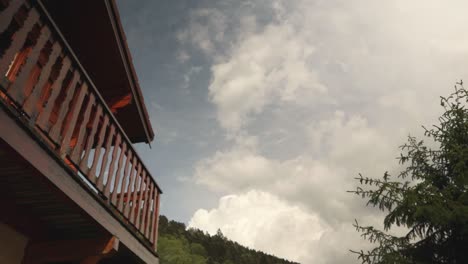 Zeitraffer-Des-Himmels-An-Einer-Holzhütte-Mit-Tannen-Und-Berg-Im-Hintergrund