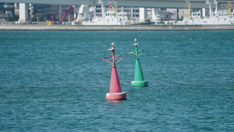 A-slow-motion-shot-of-a-red-and-a-green-buoys-floating-in-Tokyo-bay,-Japan