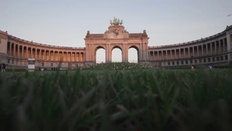 Low-wide-shot-in-the-grass-of-the-triple-Triumphal-Arch-in-Parc-du-Cinquantenaire-in-Brussels,-Belgium