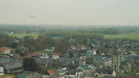 Plane-flies-low-and-close-over-the-municipality-of-Steenokkerzeel-direction-Brussels-Airport,-Belgium