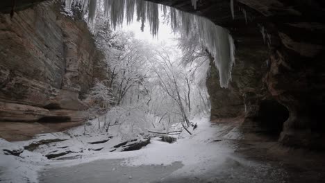 Inside-Cave,-Snow-Falling-Outside-Cave-Entrance,-Adventure-Concept