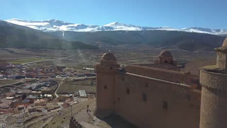 Luftaufnahme-Der-Burg-Von-La-Calahorra-Mit-Sierra-Nevada-Dahinter-In-Granada,-Spanien