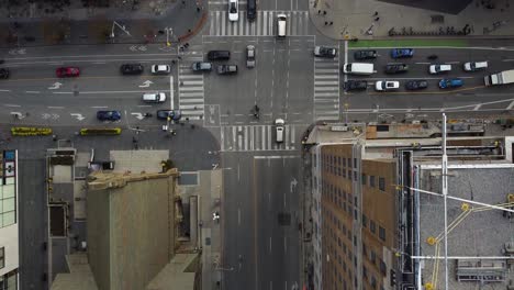 Wide-Aerial-top-down-busy-city-street-intersection-traffic-with-pedestrians-and-bikes