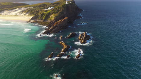 Aerial:-Lighthouse-on-clifftop-of-rugged-Australia-coastline,-tilt-up-reveal