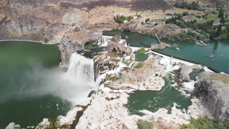 Slow-motion-aerial-view-high-above-Shoshone-Falls-pouring-into-the-Snake-River-in-Twin-Falls,-Idaho-during-the-summer