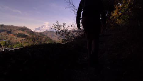 Männlicher-Wanderer,-Der-Berg-Fuji-In-Entfernung-Vom-Hügel-Betrachtet---Silhouettenaufnahme