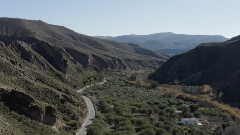 Hermoso-Valle-Montañoso-Verde-Un-Camino-Que-Atraviesa-Y-Una-Casa-Blanca