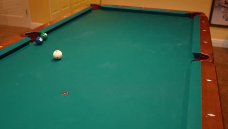 Man-Wins-a-Game-of-Pool-by-Shooting-a-Bank-Shot-on-the-Eight-Ball-into-the-Side-Pocket-of-a-Brunswick-Table-with-Green-Felt-in-the-Basement-of-a-home,-Billiard-Games