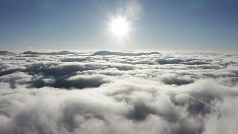 Dramatic-tall-Shanzidou-mountain-peak-rising-above-clouds,-China-aerial