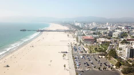 Aerial-view-above-sandy-Los-Angeles-beachfront-downtown-property-dolly-left-across-Pacific-ocean