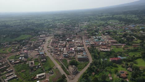 Panoramablick-Auf-Ein-Ländliches-Stadtbild-Mit-Grünen-Feldern-Und-Häusern-In-Loitokitok,-Kenia,-Tagsüber---Drohnenaufnahme-Aus-Der-Luft