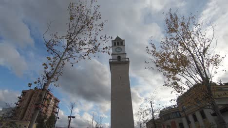 Histórica-Torre-Del-Reloj-De-Tirana-Cerca-De-La-Plaza-Skanderbeg-En-Tirana,-Albania---Amplia-Toma-Lenta-De-Inclinación-Hacia-Arriba