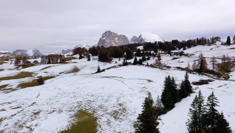 Aerial-shot-of-wooden-cabins-and-snowy-landscape-in-autumn-at-Seiser-Alm---Alpe-di-Siusi-plateau-in-the-Dolomites,-Italy