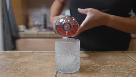 Pouring-vodka-into-a-frosted-glass-of-ice---slow-motion