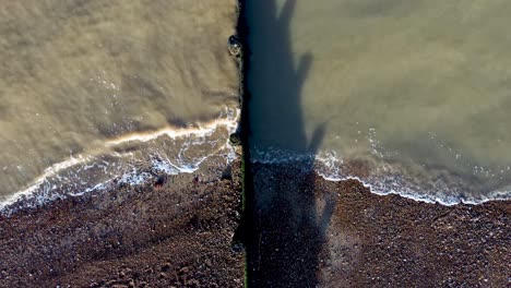 Dunkle-Meereswasserwellen,-Die-Den-Kiesstrand-An-Der-Küste-Von-Kent-Von-Herne-Bay-In-Uk-Treffen