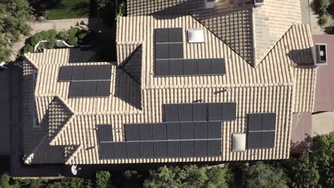 Birdseye-rising-aerial,-of-home-with-array-of-solar-panels,-alternative-energy