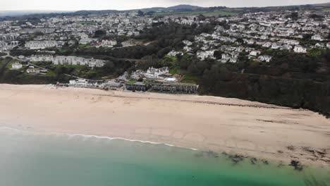 Panning-left-shot-of-Carbis-Bay-showing-the-beach,-Hotel-and-town-in-Cornwall-England-UK