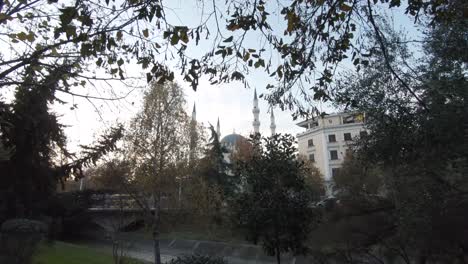 View-from-the-woods-to-Great-Mosque-of-Tirana-appearing-among-the-bushes-in-Albania---Wide-push-in-Reveal-shot