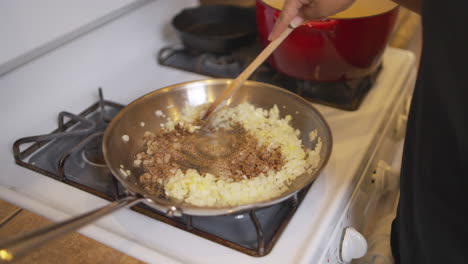 Stirring-meat-and-into-a-pan-full-of-sautéed-onions---slow-motion-isolated