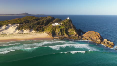 Sugarloaf-Point-Lighthouse-on-Australia-headland-clifftop,-sunset-aerial-view