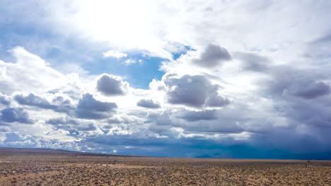 Fliegen-Sie-über-Die-Wildnis-Der-Mojave-Wüste,-Während-Sich-über-Ihnen-Dunkle-Gewitterwolken-Bilden---Hyperlapse-Aus-Der-Luft