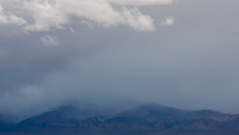 On-a-windy-winter-day,-clouds-blow-over-Southern-California's-Transverse-Mountain-Range-and-threaten-to-snow---time-lapse