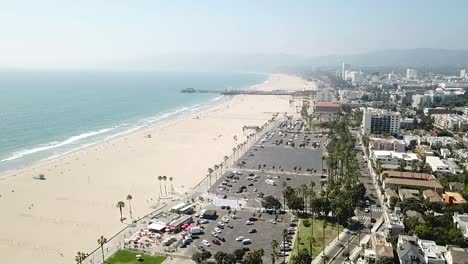 Sandy-Los-Angeles-beachfront-coastline-aerial-view-reverse-dolly-right-above-downtown-property