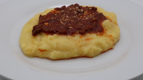 Polenta-Mit-Bolognese-Sauce-Und-Parmesan-Käse,-Isoliert-Auf-Weiss