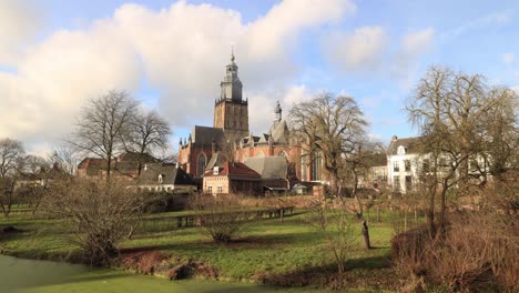 Cityscape-timelapse-with-clouds-passing-by-above-the-picturesque-medieval-church-tower-of-the-Walburgiskerk-creating-patterns-in-the-lush-gardens-in-the-foreground-of-Dutch-historic-city-Zutphen