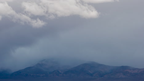 During-winter-weather,-clouds-and-fog-drift-over-the-mountain-peaks---time-lapse