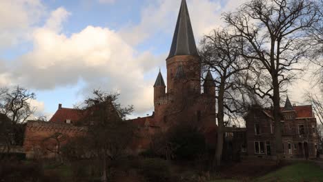 Fast-moving-clouds-in-a-timelapse-showing-the-medieval-city-wall-and-pointy-tower-with-cants-of-the-Drogenapstoren-in-historic-city-Zutphen-in-The-Netherlands-in-shade-and-in-sunlight
