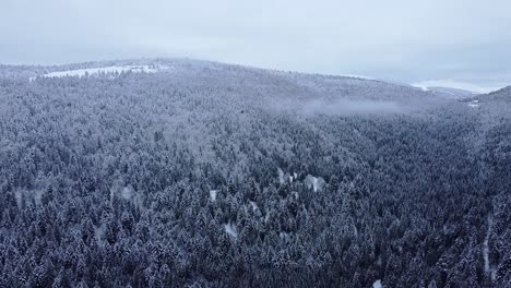 Luftige-Winterliche-Berglandschaft,-Die-Mit-Schnee-Bedeckt-Ist-Und-Nur-Wenige-Gipfel-Langsam-Fliegen-Zeigt