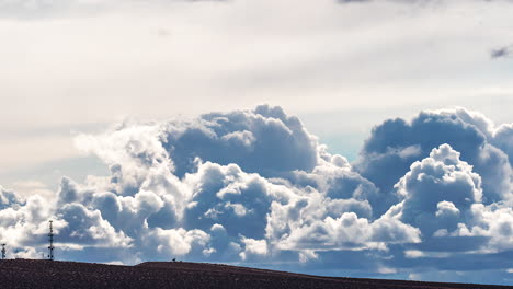 Fast-developing-and-evolving-shapes-of-cumulus-clouds-over-the-silhouette-of-a-cell-tower-on-the-Mojave-Desert-hillside---time-lapse