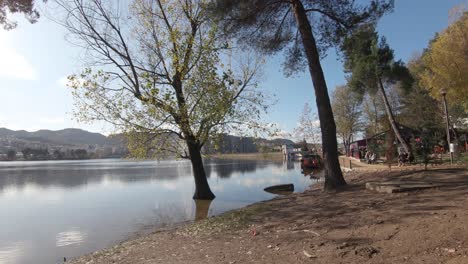 Shoreline-of-Tirana's-Grand-Park-artificial-lake-on-a-sunny-day-in-Albania---Wide-push-in-dolly-shot