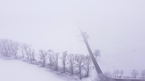 A-country-landscape-covered-with-snow-and-shrouded-in-thick-fog