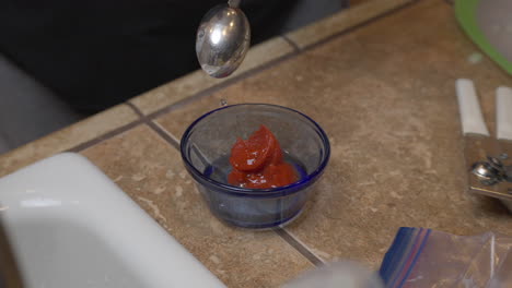 Adding-vinegar-to-tomato-paste-for-ingredients-in-a-homemade-recipe---isolated-slow-motion