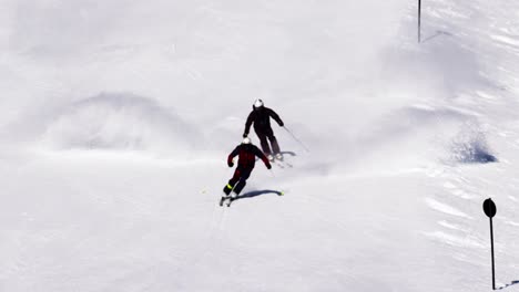 2-Männliche-Skilehrer-Fahren-Kurze-Skischwünge