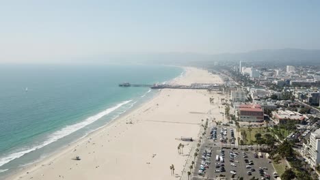 Sandy-Los-Angeles-waterfront-shoreline-neighbourhood-property-aerial-view-slow-forwards-towards-Santa-Monica-pier
