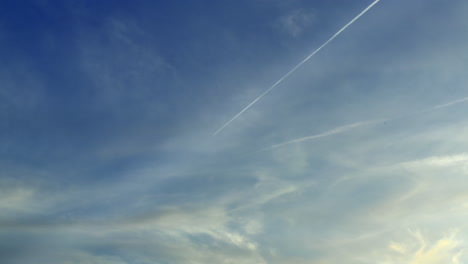 Airplane-Travelling-Against-Blue-Sky-Leaves-Vapour-Trails,-Beautiful-Clouds-In-The-Atmosphere
