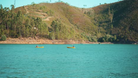 River-lake-Kayak-practice-among-green-mountain-hills-on-summertime-afternoon-at-sunshine-4K