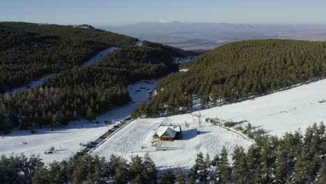 Heiterer-Flug-über-Eine-Verlassene-Hütte-In-Einem-Leeren-Skigebiet-Mit-Tiefem-Schnee
