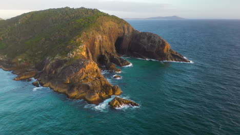 Aerial-shot-of-coastal-headland-cliffs-at-sunset