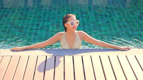 Junges-Asiatisches-Mädchen-Mit-Sonnenbrille,-Das-Sich-Im-Pool-Entspannt