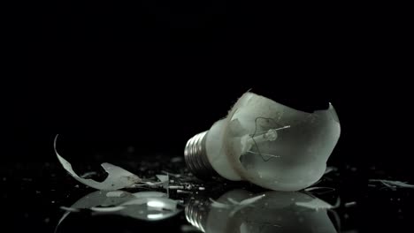 Incandescent-lamp,-light-bulb-broken-on-small-pieces-of-glass,-energy-solving-concept
