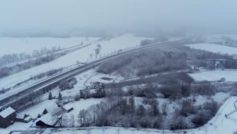 Luftaufnahme-Der-Schneebedeckten-Deutschen-Landschaft-Entlang-Der-Autobahn---LKW-Transport