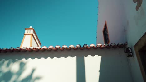 Portugal-typical-roof-chimney,-white-walls-house,-under-blue-sky-at-sunshine-4K