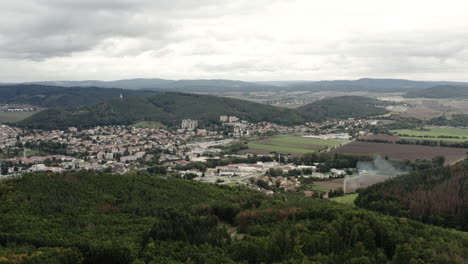 Luftaufnahme-Von-Alpinen-Bergen-Und-Landwirtschaftlichen-Landwirtschaftlichen-Flächen-Rund-Um-Die-Ländliche-Stadt,-Tschechische-Republik