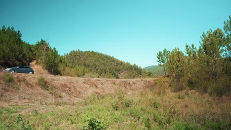 Unidad-De-Coche-En-La-Carretera-Rural-Entre-Colinas-De-árboles-4k
